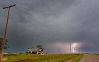 Lightning illuminates the prairie near an abandoned farmhouse during a powerful thunderstorm [IBR125527057]