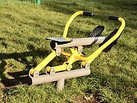 Street rowing yellow exercise machine on green grass in the yard in the city. [IBR125527068]