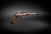 Studio shot of historic percussion disc gun pistol short weapon on black background with drop shadow dramatic light [IBR125527071]