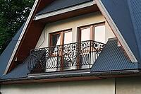 House exterior with attic and balcony creates cozy residential architecture scene. Home features decorative railings, modern design elements and suburban atmosphere for real estate, lifestyle [IBR125527081]