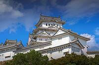 Himeji, Japan - Sep 24 2024, Panoramic view of Himeji Castle, White Heron Castle with trees and plants of park on foreground, at daytime with blue cloudy sky, without people, Himeji, Japan [IBR125527092]