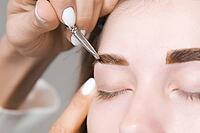 Eyebrow tinting. Close-up of a master applying eyebrow dye with a brush. Cosmetic procedures, permanent eyebrow makeup. correction and modeling of eyebrows in a beauty salon. perfect eyebrows [IBR125527096]