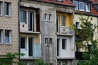 Old house with demolished balconies and weathered walls in Essen, Germany [IBR125527102]