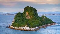 Yatsushiro, Kumamoto Pref, Japan - Oct 9 2024, panoramic aerial view of an uninhabited island covered with forest off coast of Yatsushiro, at daytime with cloudy sky, Yatsushiro, Japan [IBR125536388]