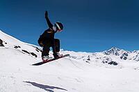 Young woman snowboarder jumping from a springboard in the snowy mountains [IBR125536392]