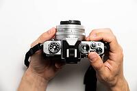 Photographer with camera on white background, close-up of hands and professional photo camera [IBR125536467]