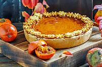 Homemade pumpkin pie, juicy persimmons and colorful autumn leaves on dark wooden background [IBR125557532]
