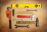 Various tools to work, hammer, tensioner, gas key, level to measure the plane. Close up on a background of craft paper [IBR125557541]