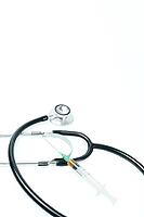 Stethoscope and syringe filled with vaccine liquid on a white background, symbolizing healthcare, prevention, and treatment [IBR125557565]