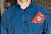 Close-up of a man in a blue shirt, the passport is visible from his pocket. Tourism and travel concept. Selective focus and shallow depth of field [IBR125557617]