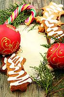Christmas balls, gingerbread and candy cane on a wooden table [IBR125565987]