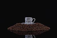 A cup of coffee on a pile of coffee beans [IBR125565990]