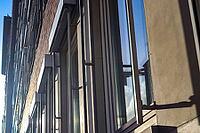 Modern office building facades with glass and reflecting sunlight in the windows found in kiel in Germany [IBR125566015]
