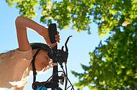 Little caucasian girl with blond hair rushing on a bicycle on a sunny summer day. View from below. Focus on the hand. Urban bike - bicycle and bicycle in the municipal park [IBR125566032]