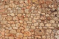 Rough reddish color stone bricks wall, sun shines on [IBR125566044]