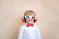 Funny kid wearing 3d glasses. Happy child having fun at home. Retro cinema concept [IBR125566046]
