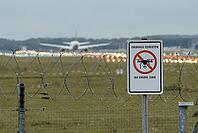 Waning sign NO DRONE ZONE am Zaun des deutschen Flughafens mit stumpfem Passagierflugzeug im Hintergrund [IBR125566051]
