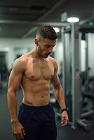 Shirtless sportsman resting after intense exercises inside a gym, AI generated [IBR125592655]