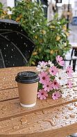 A takeaway coffee cup and pink and white flowers sit on a rain-speckled wooden café table among leafy plants. AI generated [IBR125592664]