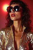 Portrait of a fashionable disco dancer wearing a gold outfit and oversized sunglasses on a red background, AI generated [IBR125592666]