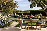A sunlit garden patio with a wooden table and two chairs, surrounded by flowering borders, clipped hedges, and an apple tree. AI generated [IBR125592704]