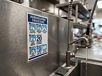 A close view of a commercial kitchen handwashing station highlights hygiene guidance, running water, a metal faucet, and food safety practices, AI generated [IBR125592708]