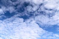 Beautiful fluffy white beautiful cloud formations in a deep blue summer sky [IBR125606086]