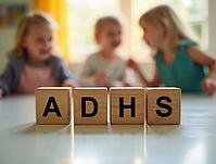 Wooden cubes showing adhd word are placed on a table with blurred children playing in the background, AI generated [IBR125621281]