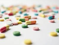 Colorful pills and capsules scattered on a white surface represent the pharmaceutical industry, medicine, and healthcare, AI generated [IBR125621295]