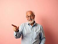 Cheerful elderly professor pointing his finger towards copyspace on a pastel pink background, AI generated [IBR125621344]