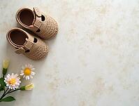 Small crocheted baby shoes and daisies are displayed on a marble countertop, creating a serene and minimalist composition, AI generated [IBR125621349]