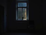 Lone person stands by a window in a dark apartment, AI generated [IBR125636891]