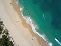 Aerial view of turquoise ocean waves washing a white sand beach in a tropical paradise, AI generated [IBR125636894]