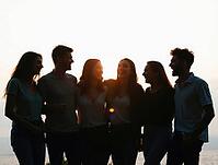 Silhouetted friends enjoying a moment of laughter and togetherness at sunset, AI generated [IBR125636909]
