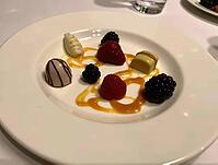 Exquisite dessert plate featuring assorted pralines, fresh berries, and a drizzle of caramel sauce, creating a luxurious culinary experience, AI generated [IBR125636916]