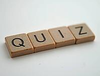 Four wooden cubes with black letters form the word quiz on a white background, AI generated [IBR125636925]
