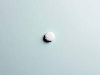 Single white pill rests on a serene light blue backdrop, creating a minimalist composition, AI generated [IBR125636945]