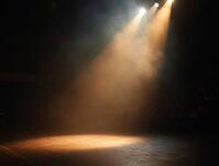 Warm spotlights illuminating an empty stage filled with smoke, creating a dramatic atmosphere, AI generated [IBR125636953]