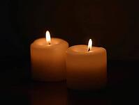 Two lit candles providing a warm glow in a dark environment, perfect for solemn occasions, AI generated [IBR125636958]