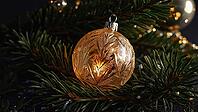 Golden christmas ball hanging on christmas tree branch with lights creating a festive atmosphere, AI generated [IBR125653406]