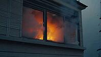 Intense fire burning inside a house, with flames and smoke billowing out of a window, creating a dramatic scene of destruction, AI generated [IBR125653408]