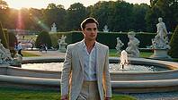 Elegant businessman walking gracefully near a stunning fountain in a formal garden adorned with statues during a picturesque sunset, AI generated [IBR125653418]