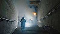 Brave firefighter ascending smoke filled staircase in burning building, demonstrating courage and dedication in life threatening situation, AI generated [IBR125653419]