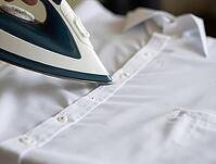 Close-up of a steam iron gliding over a crisp white shirt, removing wrinkles and creating a smooth, professional look, AI generated [IBR125653423]