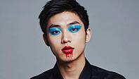 Portrait featuring a model showcasing vibrant blue and red makeup against a textured gray background, highlighting contemporary beauty and style, AI generated [IBR125653425]