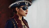 Studio portrait of a woman wearing pirate costume, eye patch and gold earrings looking away with intense expression, AI generated [IBR125653427]