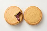 Round golden stamped cakes with one halved to show filling, Imagawayaki, Wheel cake with bean paste, batter and red bean paste, Tokyo, Kantō, Japan, dessert, confectionery, food photography, AI generated [IBR125653442]