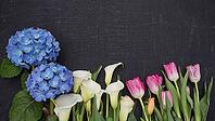 Beautiful fresh cut flowers creating a colorful border on a dark textured background with copy space, AI generated [IBR125653469]