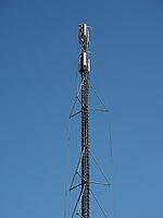 Cellular antenna tower and electronic radio transceiver equipment part of a cellular network over blue sky [IBR125654812]