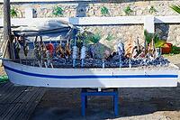 A boat-shaped grill stands over the embers and is equipped with numerous fish, Estepona, Costa del Sol, Andalusia, Malaga province, Spain [IBR125657379]